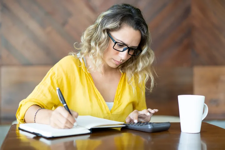 Alguien echando cuentas con la calculadora y el cuaderno